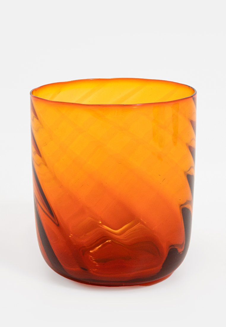 Vaso de cristal ámbar con una forma suave y curvada y una textura diagonal. El color varía de un ámbar profundo a tonos más claros.