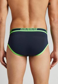 Mörkblå herrkalsonger med en limegrön midjeband med logotyp och kant. Slät tyg med åtsittande design och minimala sömmar.