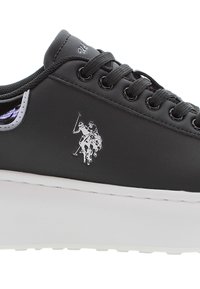 Svart sneaker med matt yta, vit plattformssula, rund tå, snörning och en silverfärgad polo-spelare logotyp på sidan.