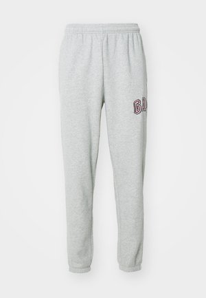 Pantaloni tuta grigi realizzati in materiale morbido, con cintura elastica e un piccolo logo bordeaux sulla coscia sinistra. Design a gamba affusolata.