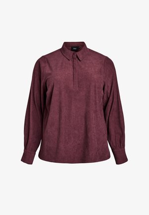 Burgundia pika varrukatega särk, millel on krae, tekstuuriga kangas ja veidi lõdvem lõige. Omab nööpidega suletud esiossa ja ribakujundust.