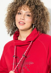 Felpa rossa con cappuccio, caratterizzata da un collo a camicia, con un design di fiocchi di neve metallici e cordini bianchi con accenti hardware argentati.