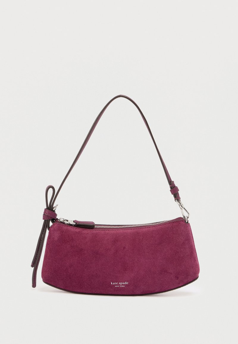 Sac à main en daim violet avec une forme courbée, une bandoulière en cuir et une fermeture éclair argentée. Nom de la marque « kate spade » affiché à l'avant.