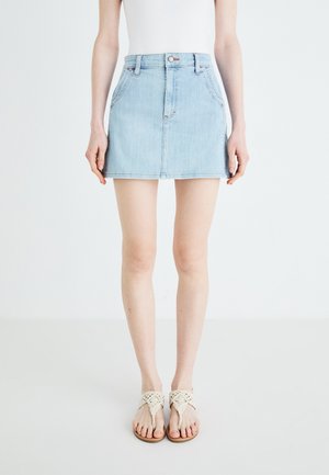 Gonna in denim azzurro chiaro con vita aderente, design a cinque tasche e orlo che arriva a metà coscia. Abbinata a sandali intrecciati beige.