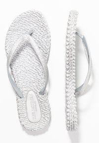 Silverfärgade flip-flops med vävd textur, glittrande remmar och en vadderad sula. Har en slät, rundad sula och prägling av varumärket.