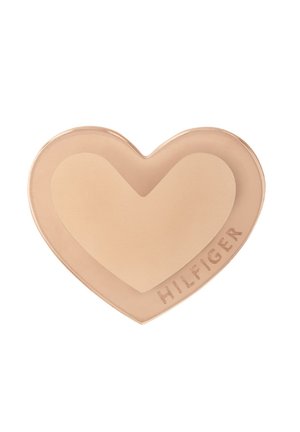 Hartvormig crèmeproduct in een lichte tan kleur, met een gladde textuur. Het logo "HILFIGER" is aan de zijkant in een contrasterende afwerking ingeperst.