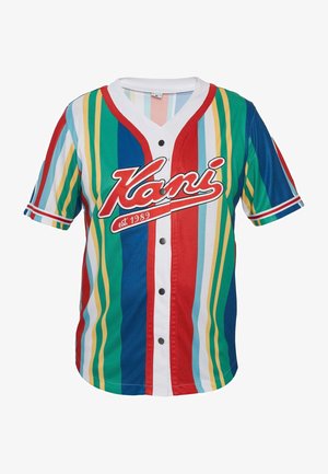 Mitmevärviline nööpidega jakk sisaldab vertikaalseid riba punases, sinises, rohelises, kollases ja valges värvitoonis. "Kani" logo on esiplaanil selgelt nähtav.