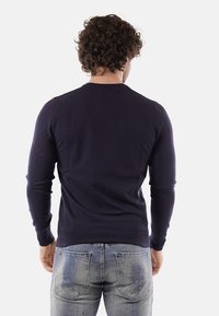 Maglione aderente blu navy realizzato in tessuto lavorato a maglia, con maniche lunghe e colletto tondo. La parte posteriore presenta una texture liscia con dettagli minimi.