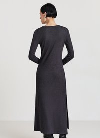 Langes dunkelgraues Kleid mit langen Ärmeln, rundem Ausschnitt, seitlichem Schlitz und einer strukturierten Stoffoberfläche. Rückansicht zeigt eine glatte Silhouette.
