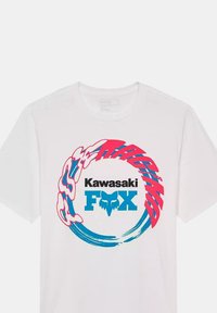 Camiseta de algodón blanca con un diseño gráfico circular. El diseño incluye "Kawasaki" en negro, "FOX" en azul y acentos coloridos en rosa y aqua.