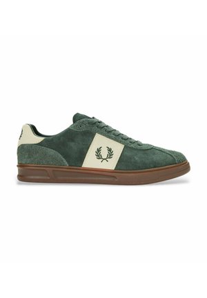 Zapatillas de ante verde con un panel crema, diseño con cordones, suela de goma y logo bordado en el lado. Textura suave con construcción robusta.