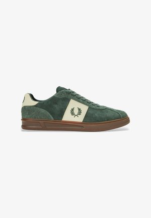 Zapatillas de ante verde con un panel crema, diseño con cordones, suela de goma y logo bordado en el lado. Textura suave con construcción robusta.