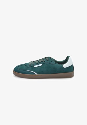 Roheline nubukist sneaker valge nahkne kand, pruun kummitald ja sobivad paelad; sisaldab õmbleeritud detaile ja peent sinist logo.