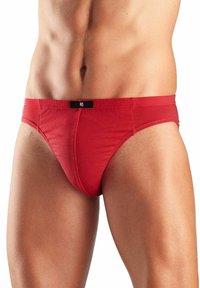 Rote Baumwollunterwäsche mit enganliegendem Design, ausgestattet mit einem schwarzen Taillenband. Glatte Textur und minimalistischer Stil.