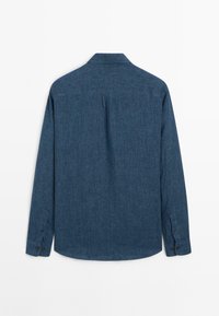 Vista posteriore di una camicia in chambray blu scuro a maniche lunghe, con polsini abbottonati, una piega centrale e colletto standard.