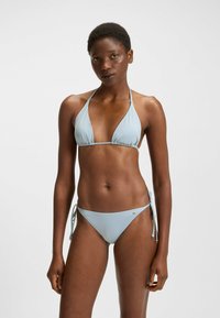 Bikini i ljusblått, med halterneck-design, trekantiga kupor och sidoband i justerbar bikinitrosa med minimal sömnad och liten hårdvarudetalj.