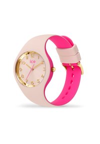 Orologio in silicone rosa e beige con quadrante rotondo color oro, indicatori delle ore rosa e logo dorato. Presenta un design curvo e un cinturino regolabile.
