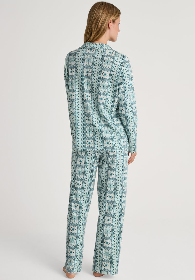 Lichtblauwe, gestreepte pyjamastelletje met een gekraagde top en rechte pijpen, versierd met ingewikkelde bloem- en geometrische patronen. Katoenen materiaal.