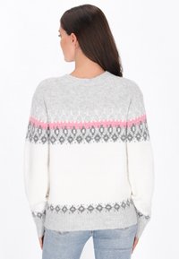 Sweater gris y blanco con un patrón y un corte holgado. Presenta una franja rosa, puños acanalados y está hecho de un material de punto suave y texturizado.
