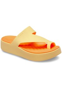 Yellow Crocs platform sandals with a thick sole, split toe design, and orange interior, featuring smooth, rubber-like material and a minimalist style.