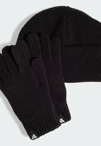 Black knitted winter beanie and matching gloves with ribbed cuffs and small white triangular logo tags.
