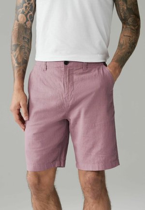 Shorts de culoare roz deschis, dintr-un amestec de bumbac, cu țesătură texturată, buzunare laterale și închidere cu buton în față, având o siluetă lejeră și o tăietură până la genunchi.