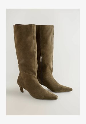 Knee-high oliivrohelised sametkingad, terava varbaga ja saleda kandaga. Omab külg zipperit sulgemiseks. Silmade tekstuur.