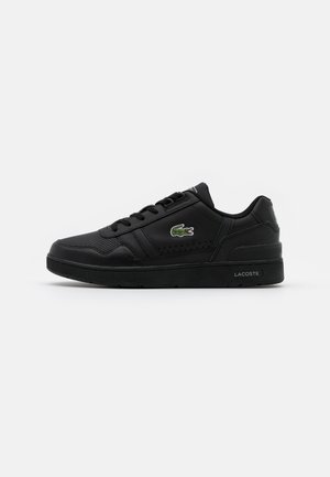 Sort lavtop Lacoste sneaker med snørebånd, perforerede detaljer og et grønt krokodillelogo på siden.