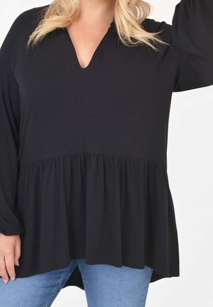 Haut noir péplum avec un décolleté en V, manches longues et une coupe décontractée. Confectionné en tissu doux, il présente une taille froncée pour une silhouette fluide.