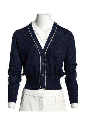 Cardigan court bleu marine à manches longues, boutonné devant, avec une bordure claire le long du col en V sur un mannequin blanc.