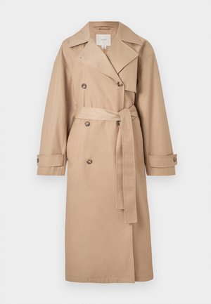 Bež dvojni preklopni plašč z pasom v pasu, velikim ovratnikom in gumbi; izdelan iz gladke, lahke tkanine.