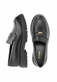 Czarne skórzane mokasyny z masywną gumową podeszwą, z szerokim paskiem i złotym akcentem na wierzchu. Gładka faktura z detalicznym przeszyciem.