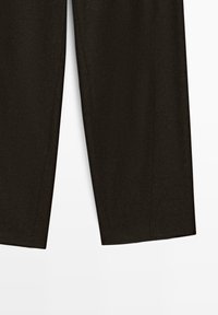 Pantalons larges noirs en tissu lisse, présentant une coupe droite, sans fermetures visibles et des coutures nettes pour un look minimaliste.