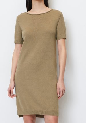 Robe tricotée à manches courtes en vert olive, avec un col arrondi, une texture douce et une longueur qui arrive juste au-dessus du genou.