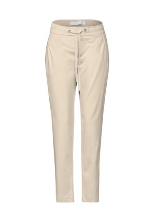 Beige tapered pants made from soft fabric, featuring an elastic waistband with a drawstring, and side pockets, with a smooth texture.