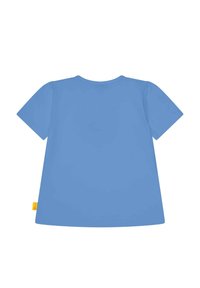 Camiseta de algodón de manga corta y cuello redondo en un suave color azul claro, con una pequeña etiqueta amarilla en el lateral. Textura suave, diseño sencillo.