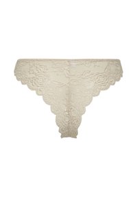 Beige kanten stringondergoed met bloemenpatronen en gegolfde randen, plat gelegd op een witte achtergrond.