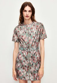 Robe à manches courtes avec une fermeture éclair en vert muted, présentant un motif de points multicolores, une taille ceinturée et deux poches avant.