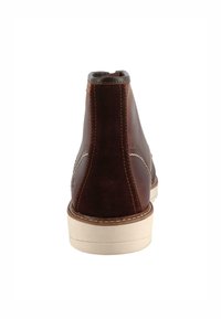 Stivaletti in cuoio marrone con pannello posteriore in suede, cuciture a contrasto e suola in gomma crema. Punta rotonda e colletto imbottito.