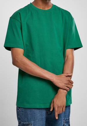 Grünes Baumwoll-T-Shirt mit kurzen Ärmeln, Rundhalsausschnitt, lockerem Schnitt und einfarbig. Strukturierter Stoff ohne Muster oder Grafiken.