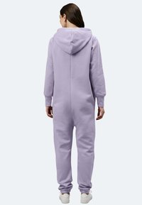 Lila Kapuzen-Jumpsuit mit langen Ärmeln, Bündchen an den Knöcheln und einem glatten, strukturierten Stoff. Verfügt über eine zentrale Naht und eine lockere Passform.