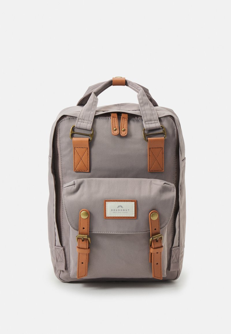 Gray canvas backpack with brown leather accents, featuring a front pocket, dual top handles, and adjustable straps. Iconic brand label visible.