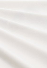 Tessuto di cotone di un morbido colore bianco crema, con una texture liscia, presenta un drappeggio sottile e una lucentezza naturale.