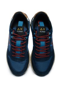 Sneakers blu marina con un mix di materiali tessili e suede. Presentano lacci arancioni, accenti blu e una suola in gomma robusta.