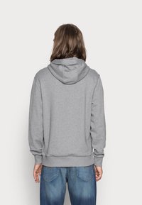 Szara bluza z kapturem wykonana z mieszanki bawełny, z kapturem, ściągaczami na rękawach i u dołu. Widok z tyłu ukazuje luźny krój i prosty design.