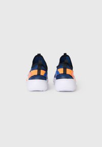 Une paire de baskets bleues avec des sangles orange vif et des semelles blanches, présentée de l'arrière sur un fond gris clair uni.