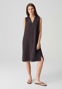 Mouwloze linnen jurk in donkergrijs met een kraag, V-hals en zijsplitten voor gemakkelijke beweging. Eenvoudige, rechte silhoeette, op knielengte.