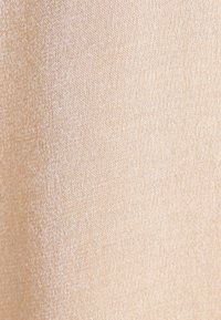 Tessuto stretch beige con una leggera lucentezza e una trama fine, che mostra una superficie liscia e leggermente riflettente. Nessun motivo o accento visibile.