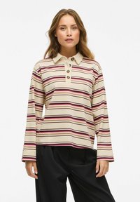 Langarm gestreeft poloshirt in beige, met bordeauxrode en roze strepen, een voorkant met drie knopen en een losse pasvorm.