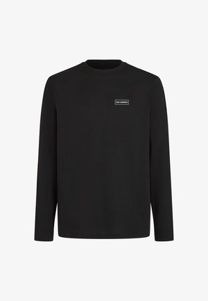 Tricou negru cu mânecă lungă din bumbac moale. Are un guler rotund și un patch mic rectangular cu logo pe piept. Design simplu, fără modele.